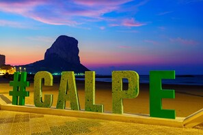 A beach with large green letters spelling 'CALPE' and a mountain in the background. - Calasanz Apartment - Plusholidays (Calpe / Calp)
