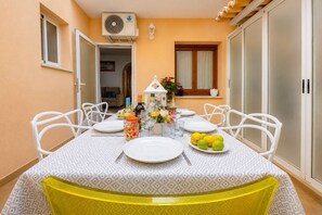 A dining area with a table set for six, white chairs, a white tablecloth, and a plate of lemons. - Calasanz Apartment - Plusholidays (Calpe / Calp)