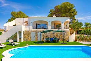A two-story house with a swimming pool, outdoor seating, and a stone wall. - Villa Lacampana - Plusholidays (Calpe / Calp)