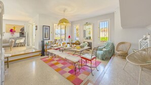 A spacious dining area with a long table, benches, and a colorful rug. - Villa Descanso - Plusholidays (Calpe / Calp)