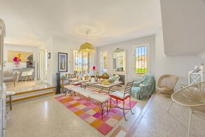 A spacious dining area with a long table, benches, and a colorful rug. - Villa Descanso - Plusholidays (Calpe / Calp)