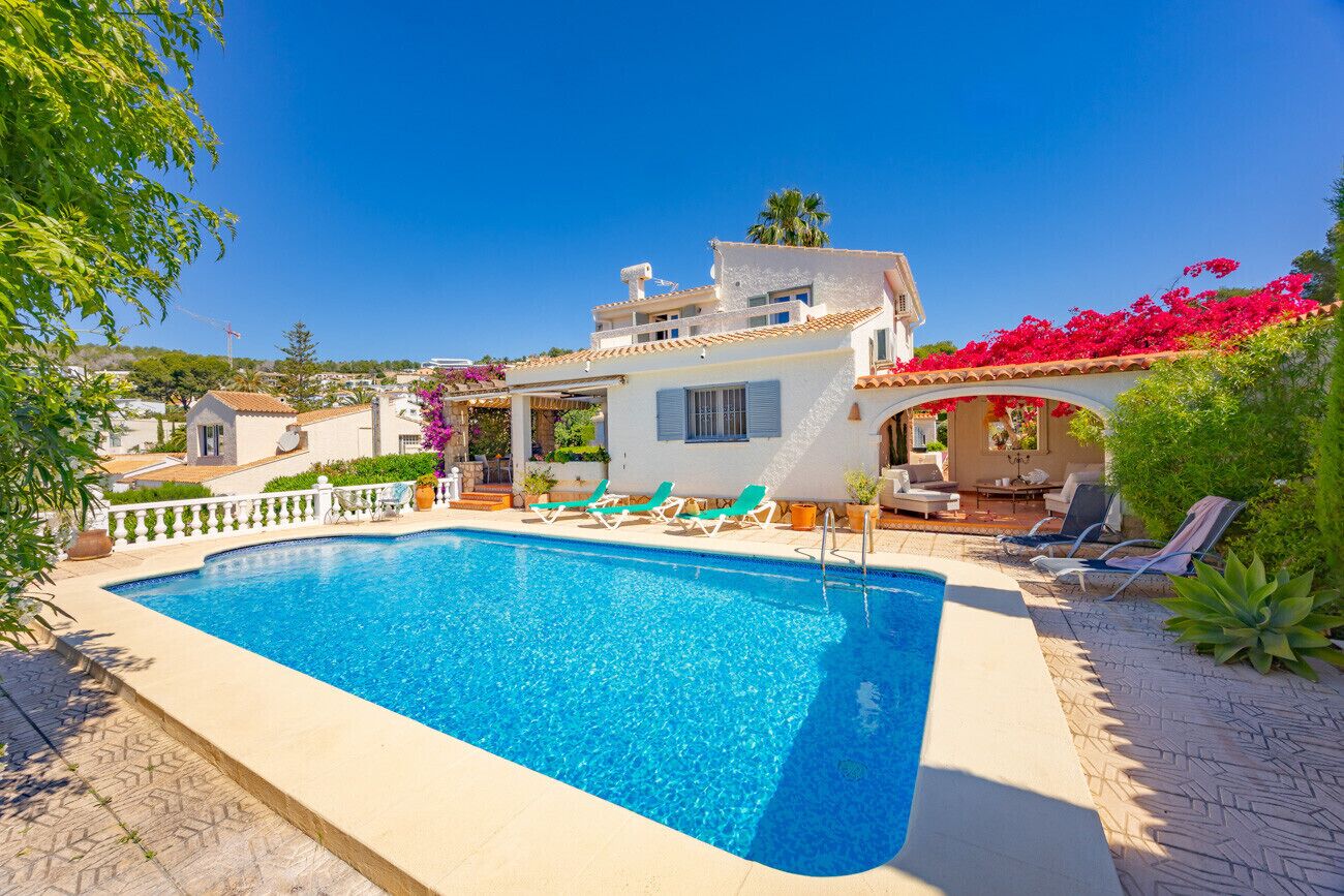Une piscine avec des chaises longues et un espace patio.
