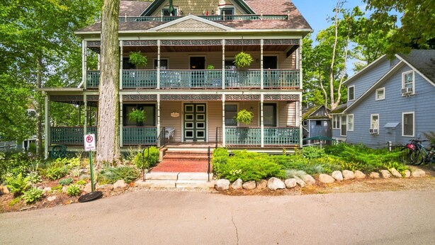 A two-story house with a balcony, a porch, and a front door. - The Arlington GB: Charming Centrally Located Condo in Chautauqua Institution! (Chautauqua)