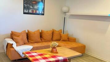 Ein modernes Wohnzimmer mit einer Couch, einem Couchtisch und einem Gemälde an der Wand.