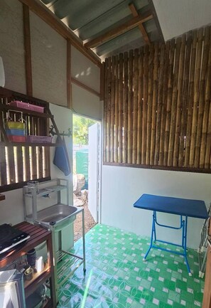 A kitchen with a sink, a stove, and a blue table. - Cozy One Bedroom Apartment Kitchen (Ko Lanta)