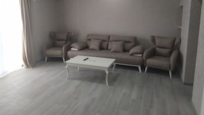 A living room with a sofa, armchairs, a coffee table, and an air conditioning unit. - ALPEDE (Zestafoni)