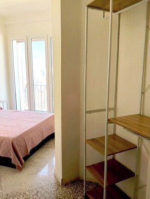 A bedroom with a bed, a wardrobe, and a balcony. - Bright Two-Room Apartment in Syracuse Near Ortigia & the Sea (Siracusa)