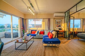 A modern living room with a sofa, coffee table, and a glass partition. - 4.97 Super Host`s New Boutique & Prime Location (Limassol)
