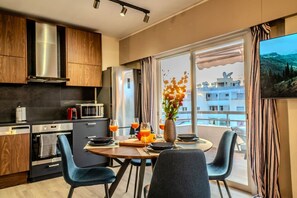 A modern kitchen with a dining area, large windows, and a view of the city. - 4.97 Super Host`s New Boutique & Prime Location (Limassol)