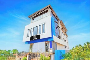 A modern multi-story building with a prominent 'Collection' sign, large windows, and a staircase leading to the entrance.