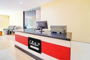 A reception desk with a computer monitor, a telephone, and a sign indicating 'Collection Company-Serviced'.
