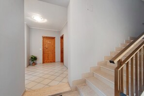 Un escalier avec des rampes en bois et des marches de couleur beige menant à un palier.