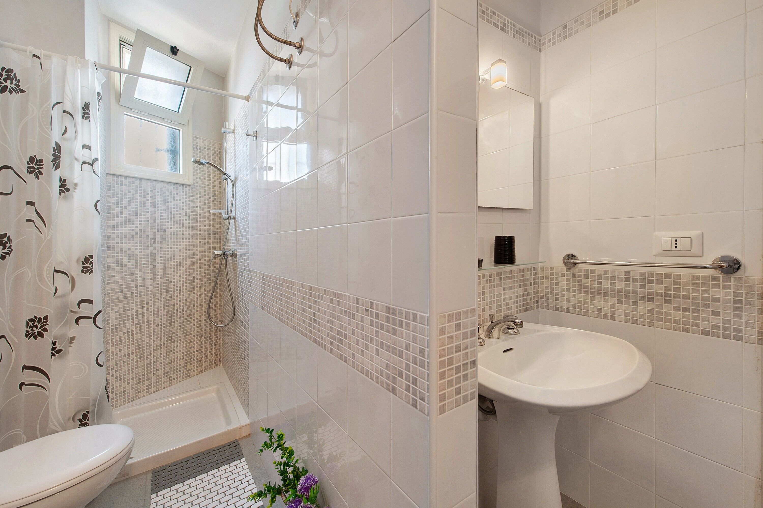 Ein Badezimmer mit Dusche, Toilette und Waschbecken.