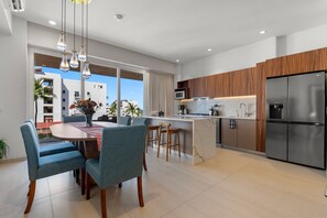 A modern kitchen with a central island, wooden cabinets, and stainless steel appliances. - Luxury 2BR Lock-Off | Rooftop Pool | Golden Zone (Nuevo Vallarta)