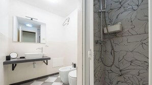 A modern bathroom with a sink, bidet, and shower. - Estay - The Corner House Cagliari Room 1 (Cagliari)