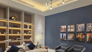 Ein modernes Interieur mit einer Sofagarnitur, einem Bücherregal und einer Wand mit gerahmten Bildern.