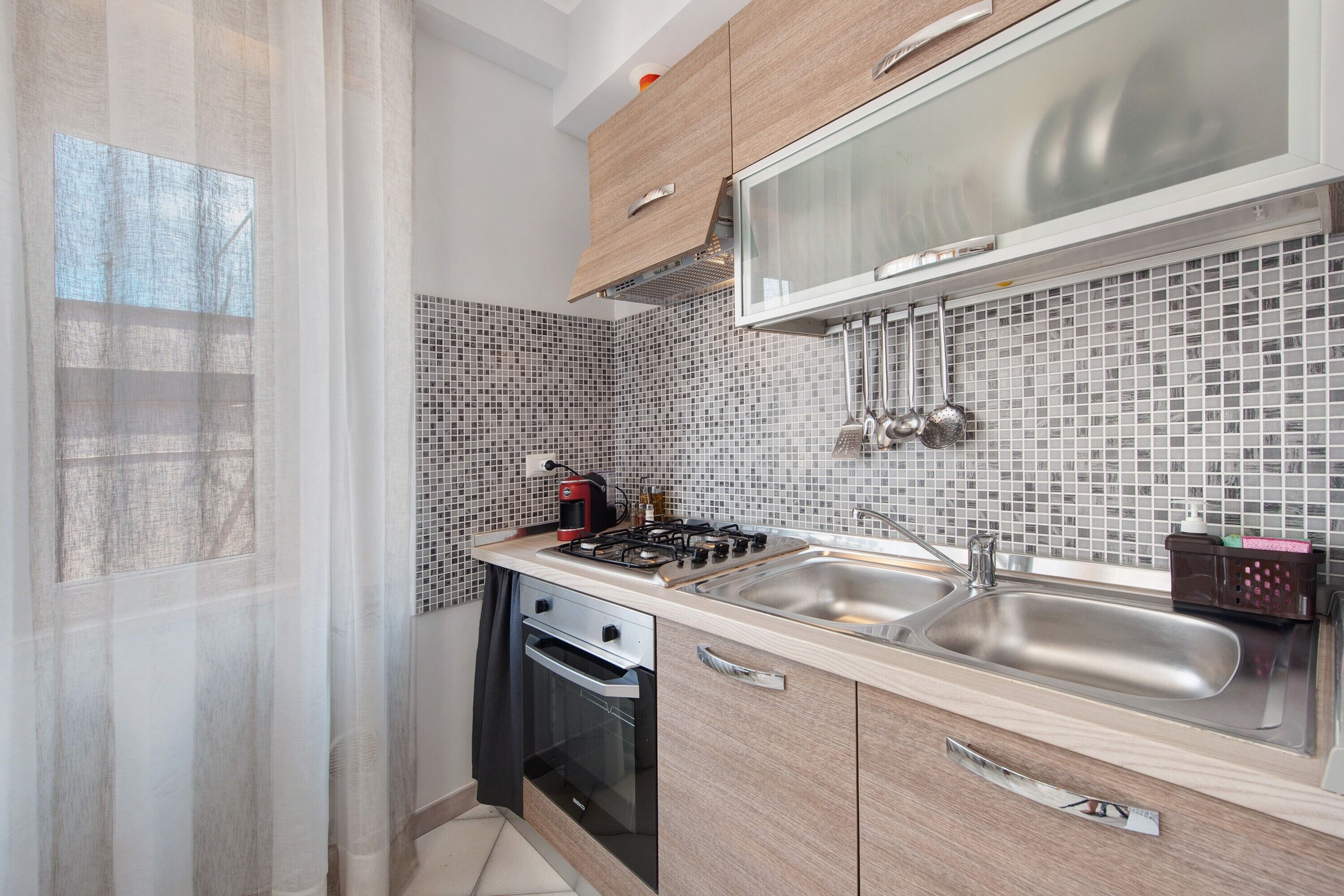 A compact kitchen with a built-in stove, a sink, and a microwave.