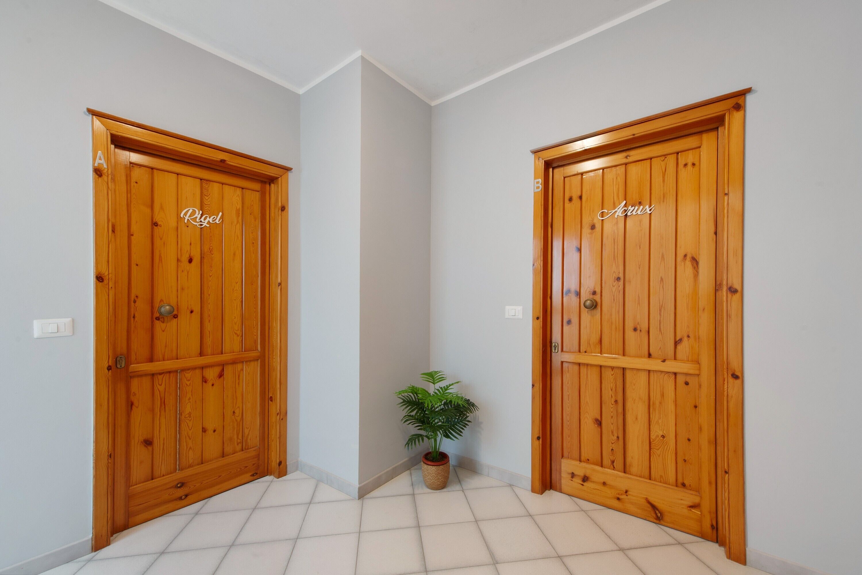 A hallway with two wooden doors labeled 'Rigel' and 'Acrix'.