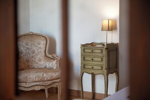 Un fauteuil de style vintage et une petite commode à tiroirs, tous deux ornés de motifs décoratifs.