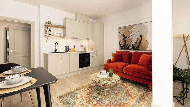 A modern living space with a kitchen, dining area, and a red sofa. - Pelican House No.3 | Luxury Apartment | Walk to the Beach | Bournemouth Centre (Bournemouth, Christchurch and Poole)