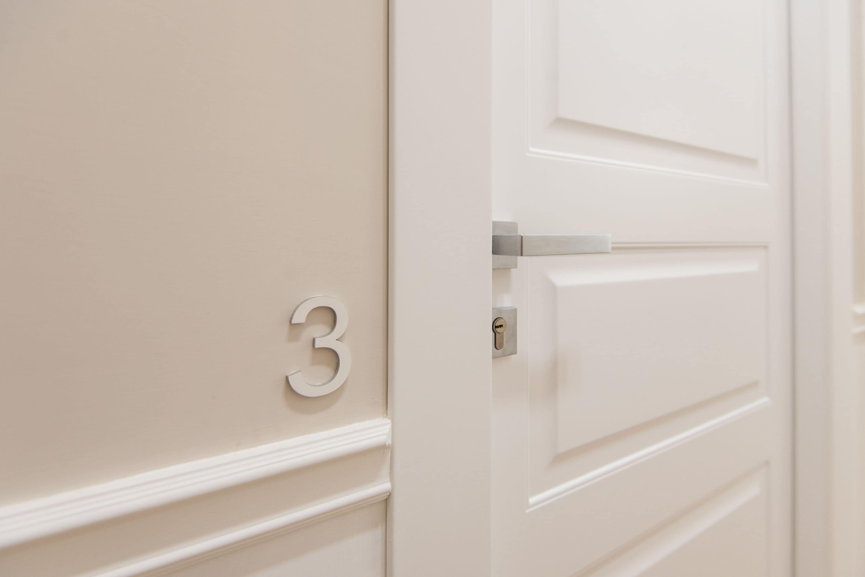 A white door with a number '3' and a keyhole.