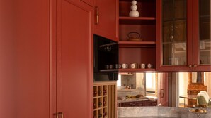 A kitchen with red cabinetry, a built-in wine rack, and a countertop with a sink. - Dimora Dell’Arcangelo La Loggia (Lucca)