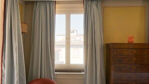 A room with a window, a chair, a dresser, and a lamp. - Dimora Dell’Arcangelo La Loggia (Lucca)