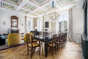 A spacious dining area with a long table, wooden chairs, and a chandelier. - Dimora Dell’Arcangelo Piano Nobile (Lucca)