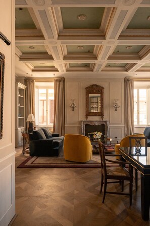 A spacious room with a fireplace, a dining table, and comfortable seating. - Dimora Dell’Arcangelo Piano Nobile (Lucca)