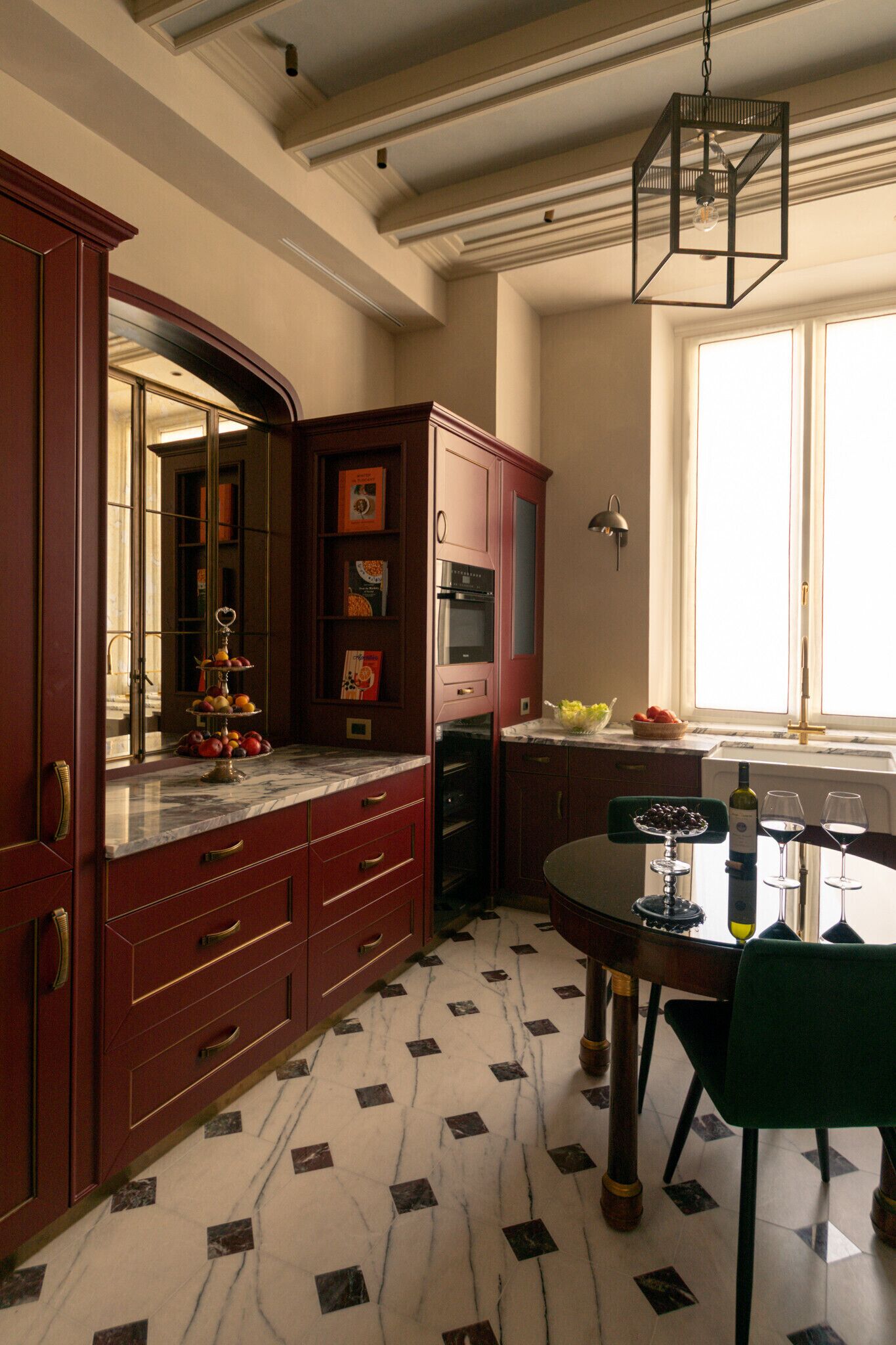 Una cocina con suelo de mármol, armarios de madera, una mesa de comedor con sillas y una lámpara colgante.
