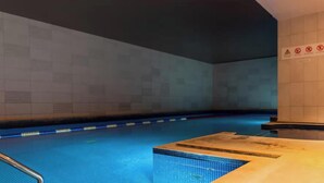 A swimming pool with tiled walls and a wooden deck area. - Pelican House No.6 | Luxury Apartment | Walk to the Beach | Bournemouth Centre (Bournemouth, Christchurch and Poole)
