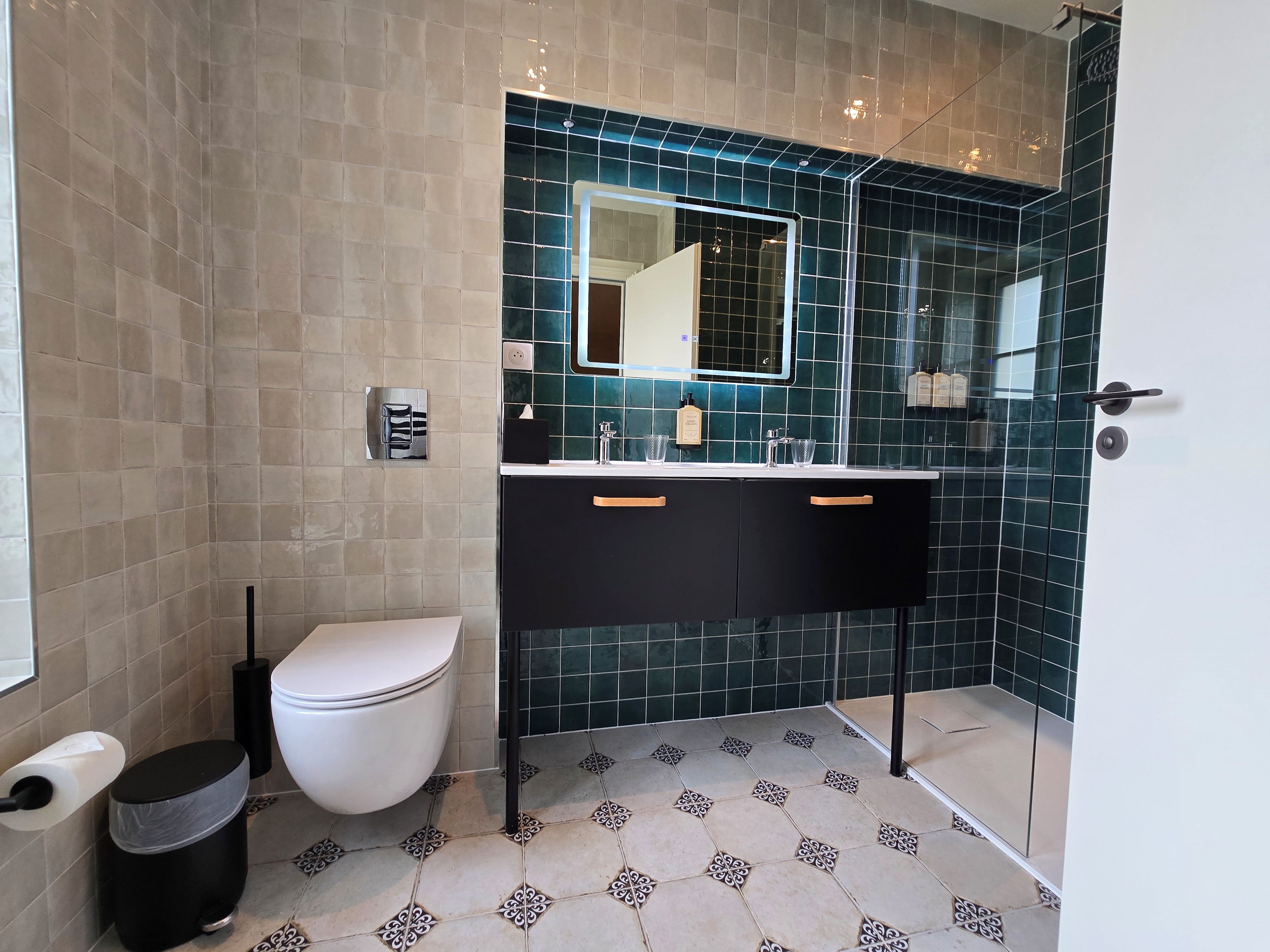 Un baño moderno con inodoro, lavabo y espejo.