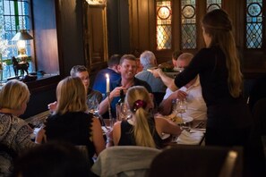 A group of people dining at a restaurant with wooden paneled walls and stained glass windows. - Kensington Studio Gem - Rare find by Holland Park (Greater London)