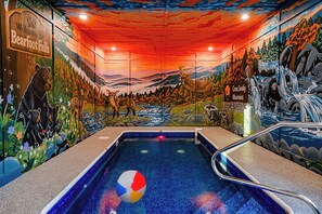 Ein Hallenbad mit einer Tierwelt-Mural und dem Schild 'Bearfoot Falls'.