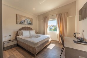 A bedroom with a bed, bedside table, and a window with curtains.