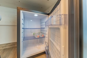 An open refrigerator with shelves and a freezer compartment.