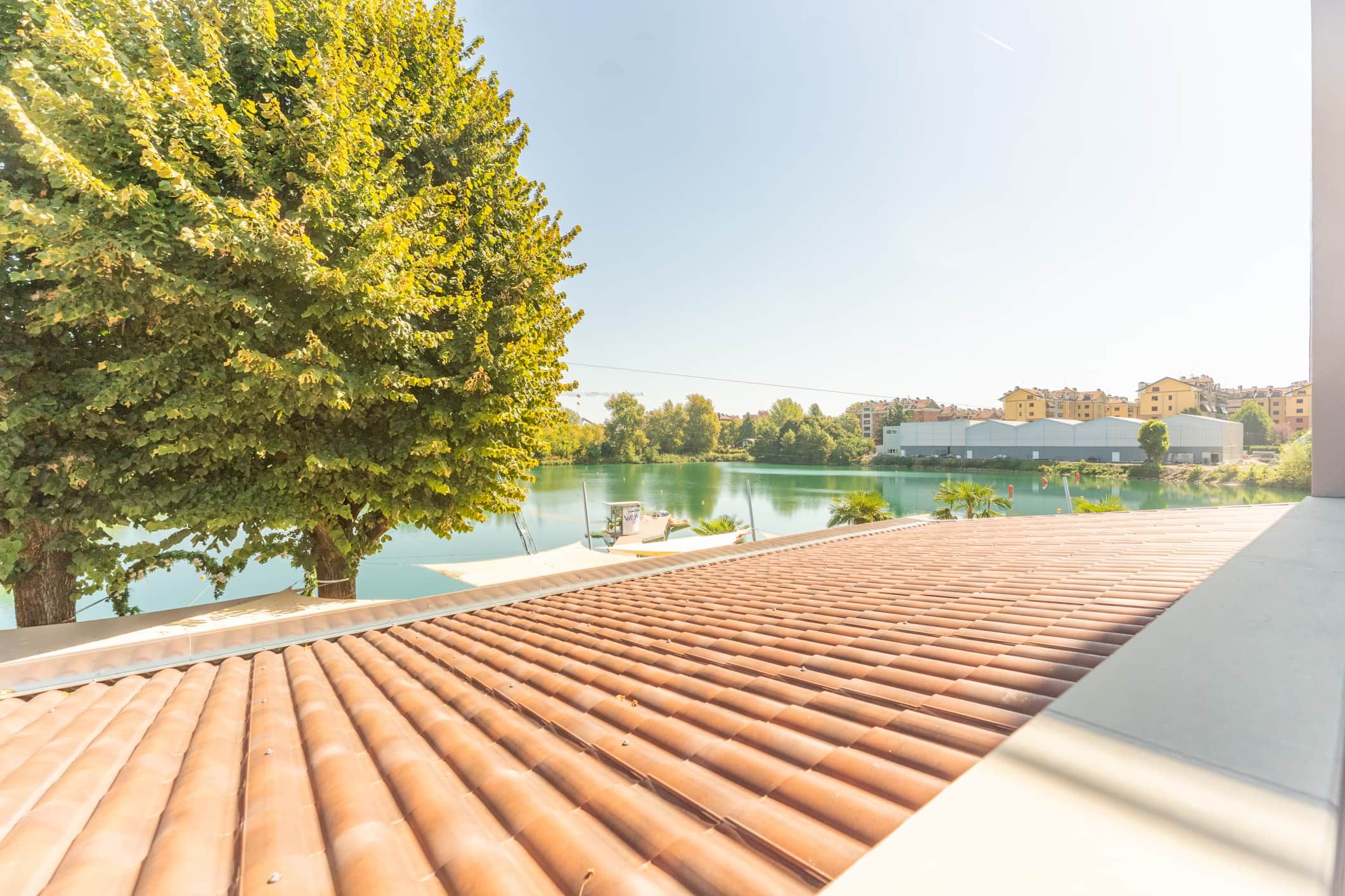 Une terrasse sur le toit offrant une vue sur un lac et des bâtiments en arrière-plan.
