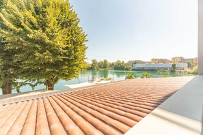Eine Dachterrasse mit Blick auf einen See und Gebäude im Hintergrund.