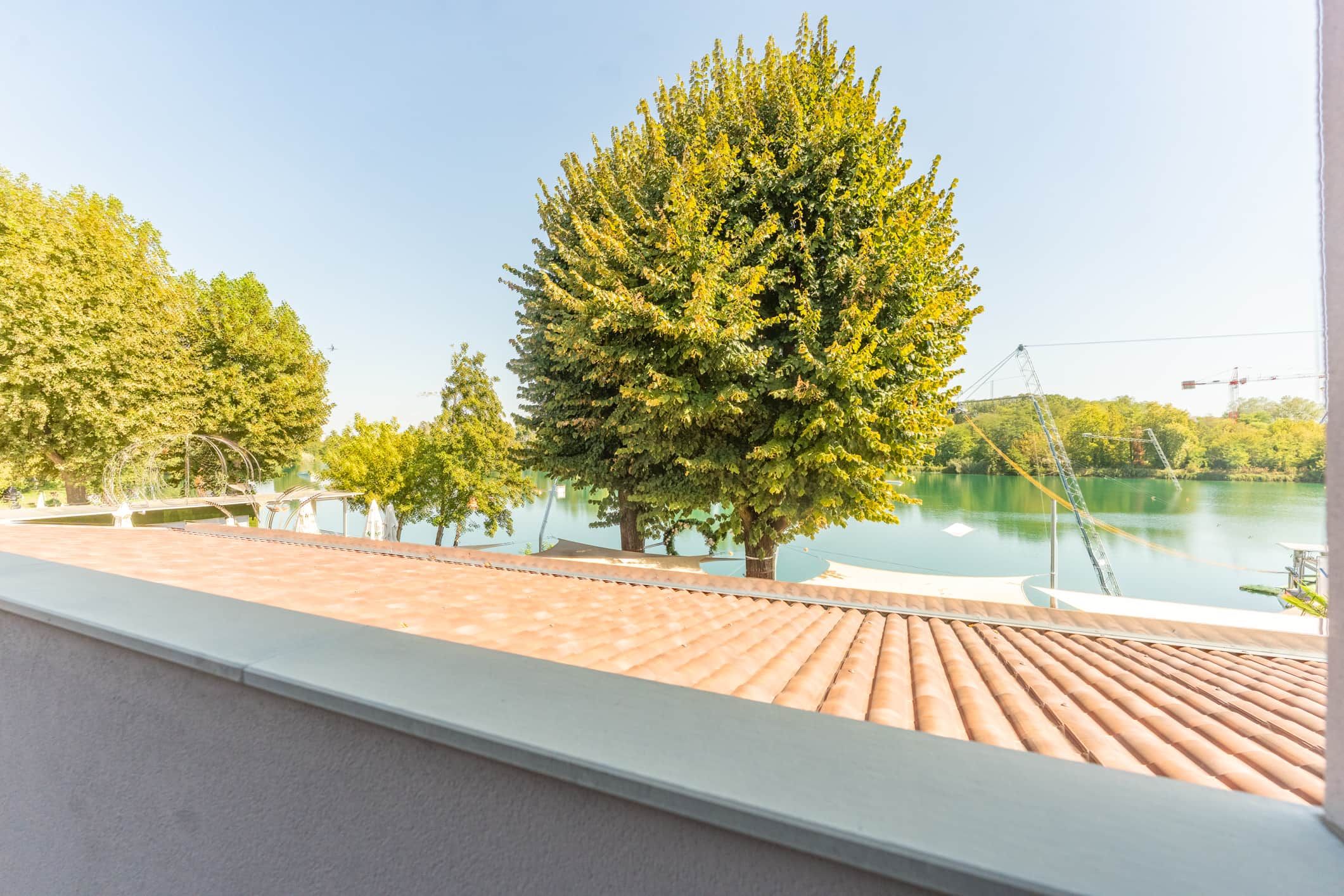 Ein Balkon mit Blick auf einen See und Bäume.