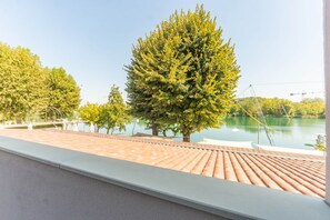 Ein Balkon mit Blick auf einen See und Bäume.