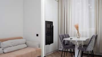 Un espace de vie moderne comprenant un canapé, une table à manger, des chaises et un appareil de climatisation.