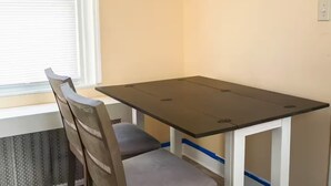 A small dining table with chairs, positioned near a window with blinds. - Cozy 2BR Apt 2 mi from Airport /PHL/ Free Parking (Prospect Park)