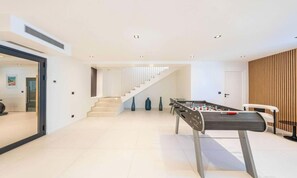 Ein modernes Interieur mit Tischfußball, einer Treppe und minimalistischem Design.