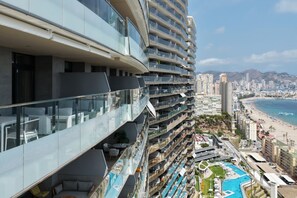 A high-rise hotel with multiple balconies, a pool area, and a view of the beach. - SUNSET SAILORS prestige apartment (Benidorm)
