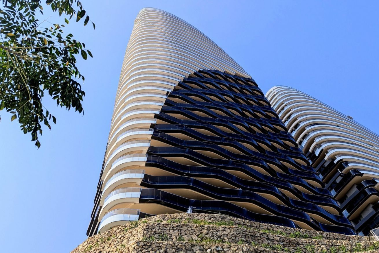 Un edifici modern amb façana corba i una sèrie de balcons.