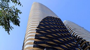 Un edificio moderno con fachada curva y varios balcones.