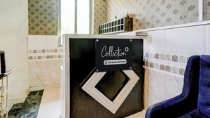 Habitación con letrero que indica servicio de recolección, papel tapiz estampado y una silla azul.