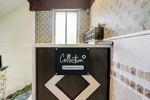 A room with a window, a decorative wall, and a sign that reads 'Collector Company Serviced'.