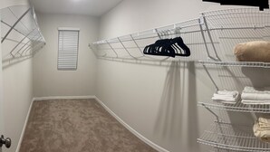 A corner closet with wire shelving units, a beige carpet, and a white door. - Spacious 5 bedroom in Haines city, Florida for families sleeping up to 12 guests (Haines City)