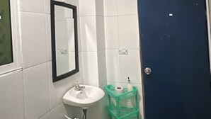A bathroom with a toilet, sink, mirror, and a blue door.